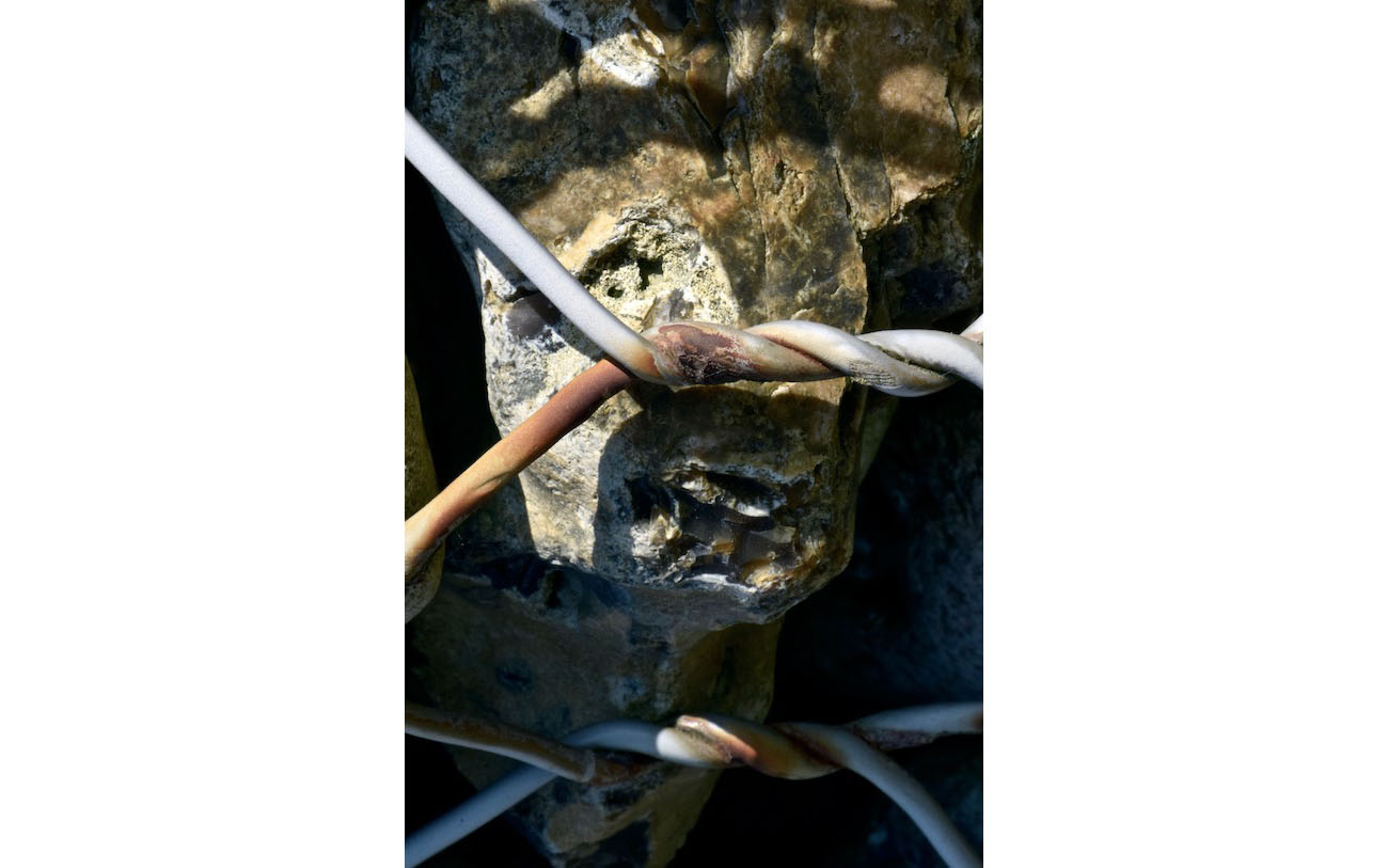 Derrière une double torsade du grillage rouillé par endroit l'oeil et la bouche expriment l'intensité de l'épouvante. L'enfer du gabion 17-l'oeil de l'épouvante-Les pierres du chemin- Photo J Lamy 2019.